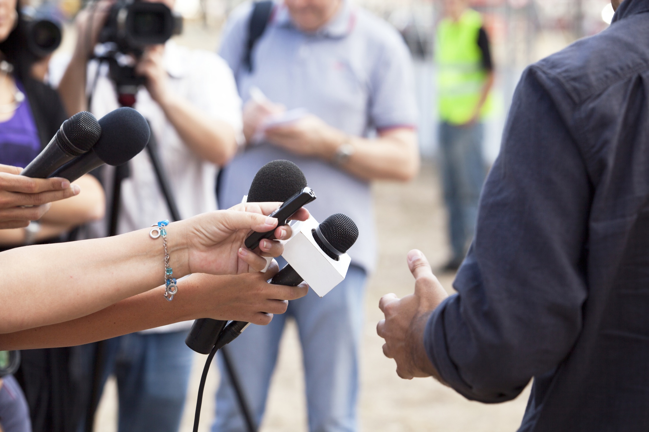 Des journalistes interviewant une porte-parole
